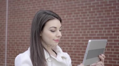 sokakta duran ve tablet bilgisayarı kullanan kadın