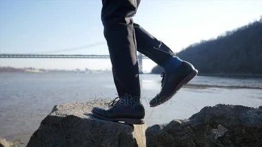Kayaların üzerinde yürüyen bir genç adam