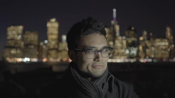 Азіатський чоловік стоїть в місті вночі — стокове відео