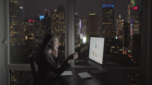 Mujer de negocios trabajando en la computadora y hablando en el teléfono móvil — Vídeo de stock