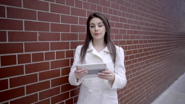 Sokakta duran ve tablet bilgisayarı kullanan kadın — Stok video