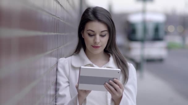 femme debout sur la rue et utilisant une tablette 