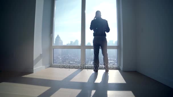 Silhouette of person talking on the phone in office — Stock Video