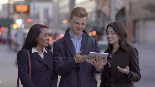 Amigos olhando para um computador tablet, falando e se divertindo — Vídeo de Stock