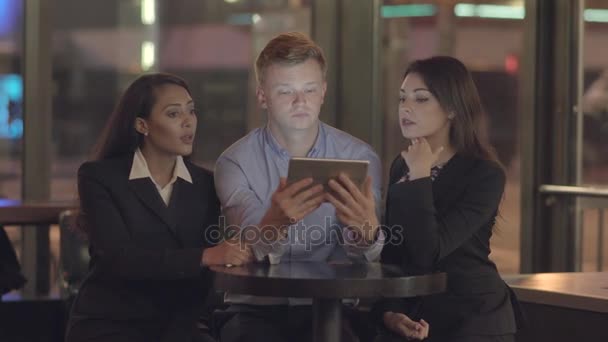 Freunde schauen auf einen Tablet-Computer, unterhalten sich und haben Spaß — Stockvideo