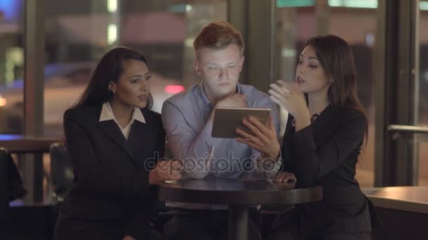 Amigos mirando una tableta, hablando y divirtiéndose — Vídeos de Stock