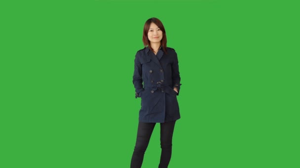 Asiática mulher de pé contra fundo verde — Vídeo de Stock