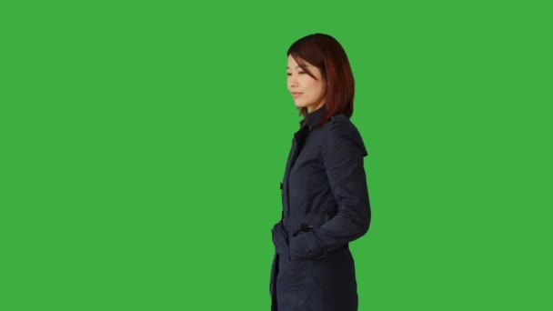 Asian woman standing against green background — Stock Video