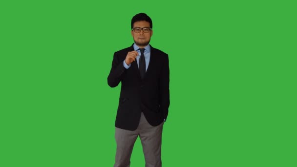 Azjatycki człowiek rozmawia na zielonym tle — Wideo stockowe