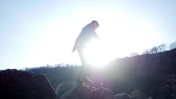 한 젊은 남자가 바위에 걸어 — 비디오
