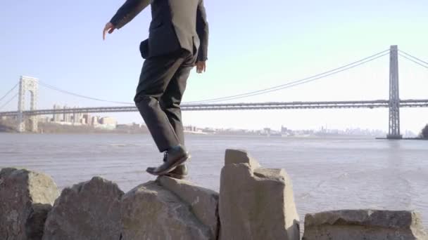 Один молодой человек ходит по скалам — стоковое видео