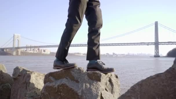 Un joven caminando sobre rocas — Vídeos de Stock