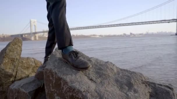 Un joven caminando sobre rocas — Vídeos de Stock