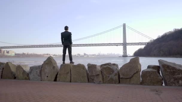 Человек, стоящий на улице у реки — стоковое видео