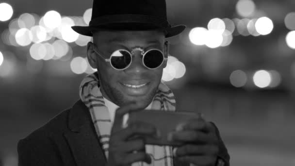 Чорний чоловік використовує мобільний телефон — стокове відео