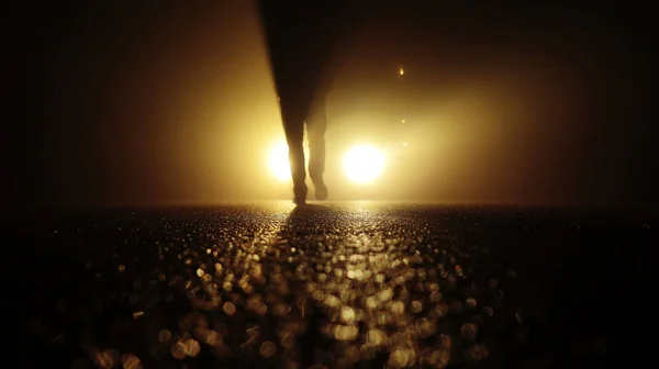 Persona caminando contra las luces del coche — Foto de Stock