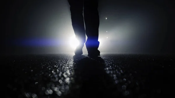 Persona caminando contra las luces del coche —  Fotos de Stock