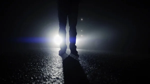 Person walking against car lights — Stock Photo, Image