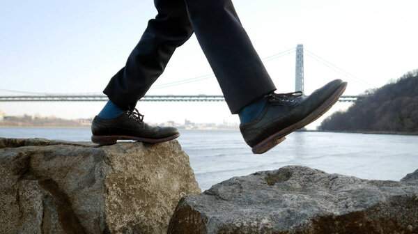 businessman walking on boulders