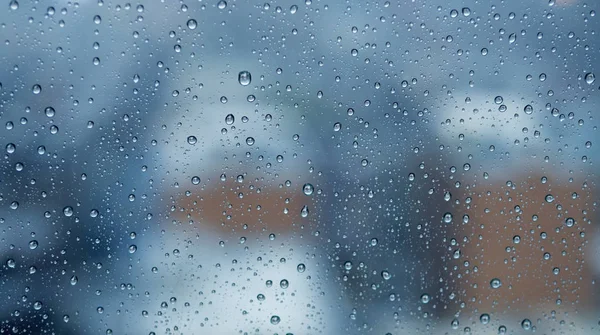 Regen druppels op venster met wazig stad — Stockfoto