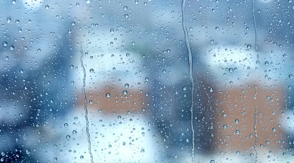 Gocce di pioggia sulla finestra con città sfocata — Foto Stock