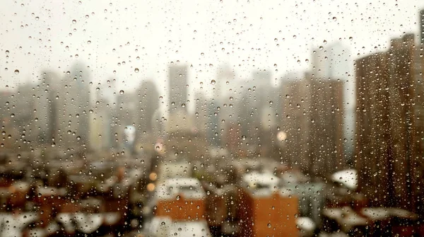 Rain drops on window with blurred city — Stock Photo, Image