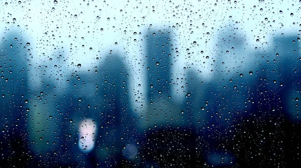 Regen druppels op venster met wazig stad — Stockfoto