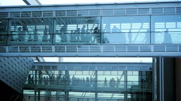 Personnes marchant à travers le bâtiment de couloir en verre — Video