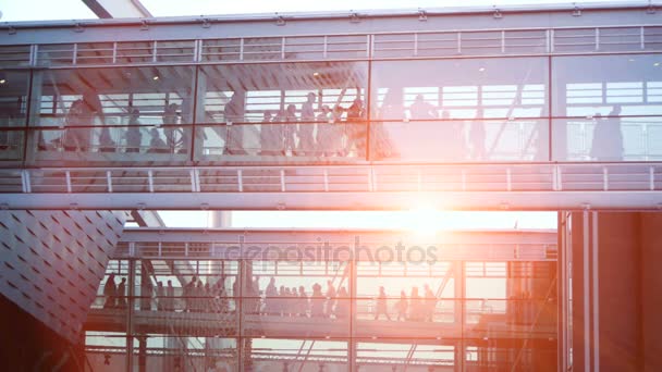 People walking through glass hallway building — Stock Video