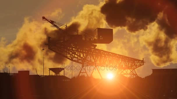 Jeřáb pracuje v průmyslovém při západu slunce — Stock video