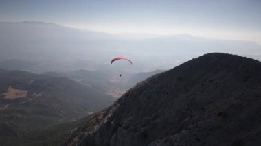 Paragliderler dağdan havalanır. Aşırıya kaçmış. Kanında adrenalin var. Güzel manzara