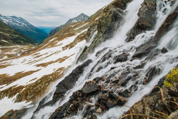 Альпійський водоспад у горах. Альпи. Сніг. Зображення плакату . — стокове фото