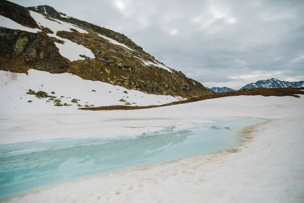 Kar dağlardan eriyor ve derede akıyor, yakın. Bir nehirde buz altından akar su ayrıntılı bir görünüm.