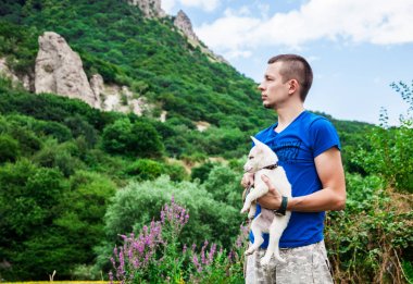 Şirin köpek yavrusu dağlarda sarılma bir adam portresi