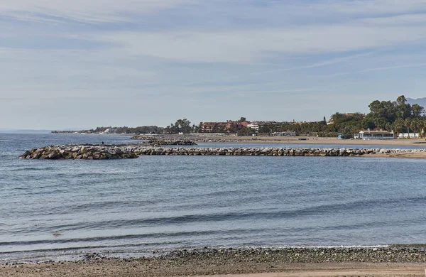 Beach with breakwater in Marbella, summer day — Stok fotoğraf