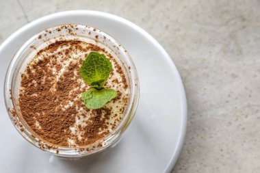 Üzerinde nane yaprağı olan tiramisu tatlısı.