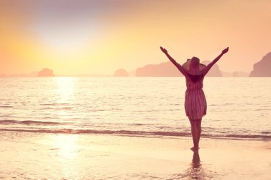 Bir şapka ve kısa elbise mutlu kadın'nde deniz günbatımı sahiptir. Denize, vintage renk arka plan dağlık karstik dağlarda