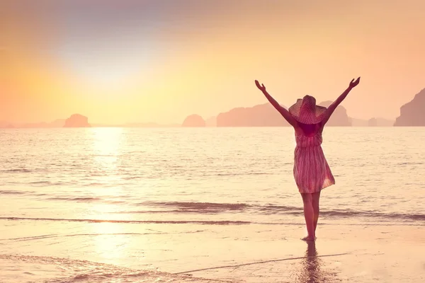 Mujer feliz en un sombrero y vestido corto disfruta en Sea Sunset. En el fondo montañas kársticas montañosas al mar, color vintage — Foto de Stock