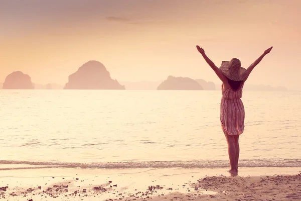 Mujer feliz en un sombrero y vestido corto disfruta en Sea Sunset. En el fondo montañas kársticas montañosas al mar, color vintage — Foto de Stock