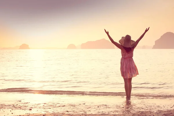 Mujer feliz en un sombrero y vestido corto disfruta en Sea Sunset. En el fondo montañas kársticas montañosas al mar, color vintage — Foto de Stock