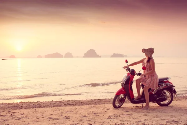 Mujer feliz en vestido corto disfruta en Sea Sunset se sienta en una scooter. En el fondo montañas kársticas montañosas al mar, color vintage — Foto de Stock