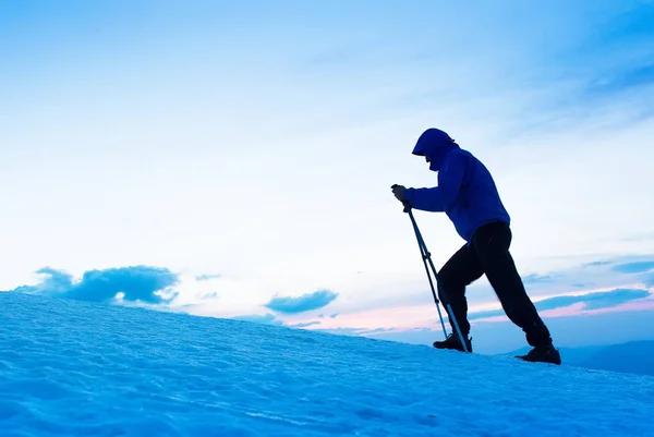 Vid skymning en modig offpist skidåkare når toppen på berget efter en lång dag promenader i vildmarken. Äventyr och utforskning koncept. — Stockfoto
