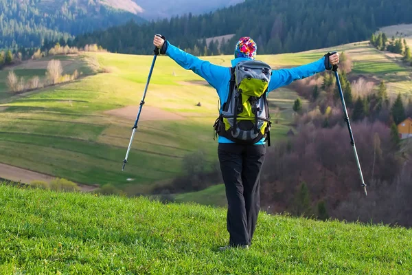 Gesunde Wanderin in der Natur wandern. schöne junge Frau wandert glücklich sitzt auf einer Wiese. Hintergrund schöne Berge und blauer Himmel mit Wolken — Stockfoto