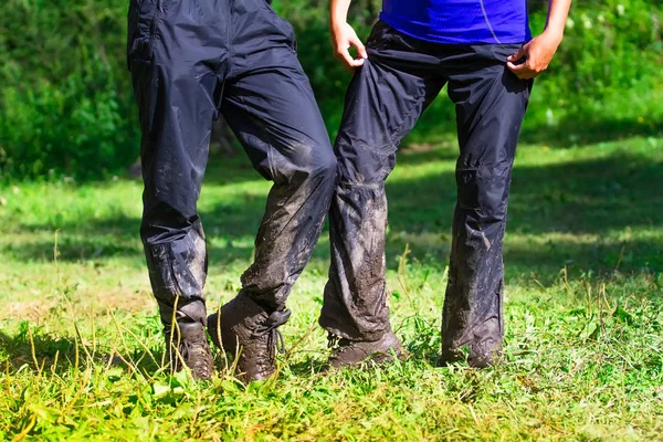 Ein Touristenpaar nach der Überwindung schwieriger Hindernisse in den Bergregionen der unbefestigten Straße. Hose, Stiefel im Matsch. — Stockfoto