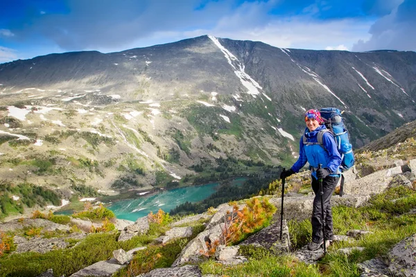Escursionista con zaino e bastoni da trekking per superare le difficoltà nelle montagne di Altai, Federazione Russa — Foto Stock