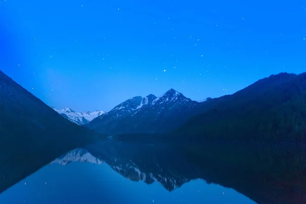 Magic night landscape with mountains, frozen lake and amazing starry sky. — Stock Photo, Image