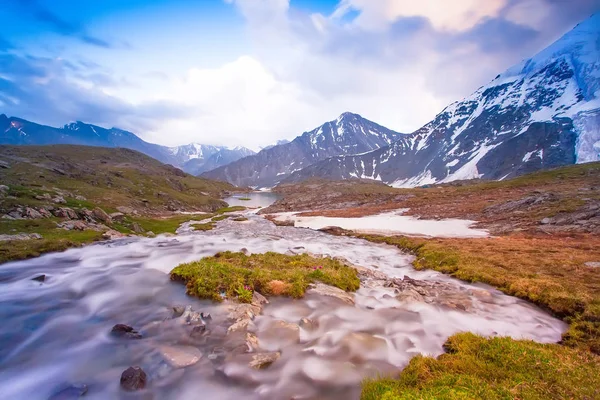 Ландшафт с горами и снежными вершинами и сгладил реку перед закатом — стоковое фото