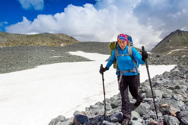 Tired girl goes on the rocks in a difficult mountain hike. — Stock Photo, Image