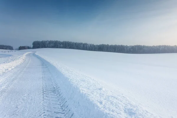 Зимний пейзаж с дорогой в снегу — стоковое фото