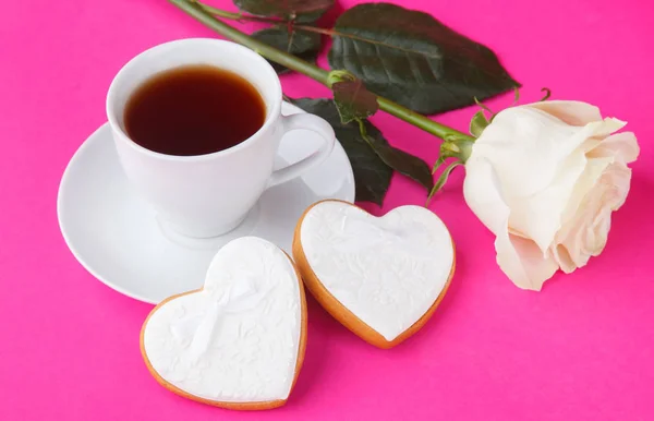 Biscoitos em forma de coração e uma rosa no fundo rosa, um presente f — Fotografia de Stock